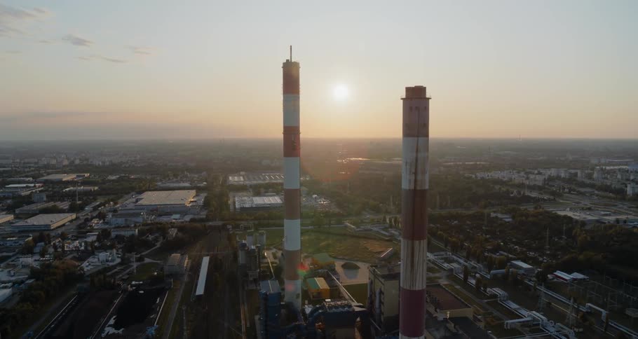 A factory with two chimney stacks with the sky in the background