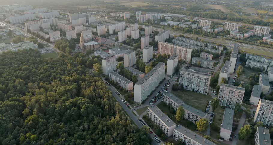 A forested area lies next to an urban area with several high rise buildings