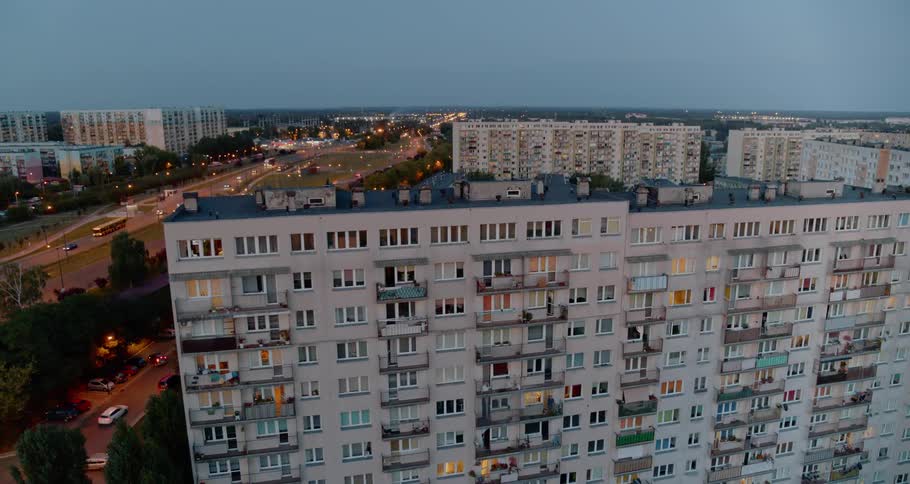 Tall thin apartment buildings surround lower buildings near busy road