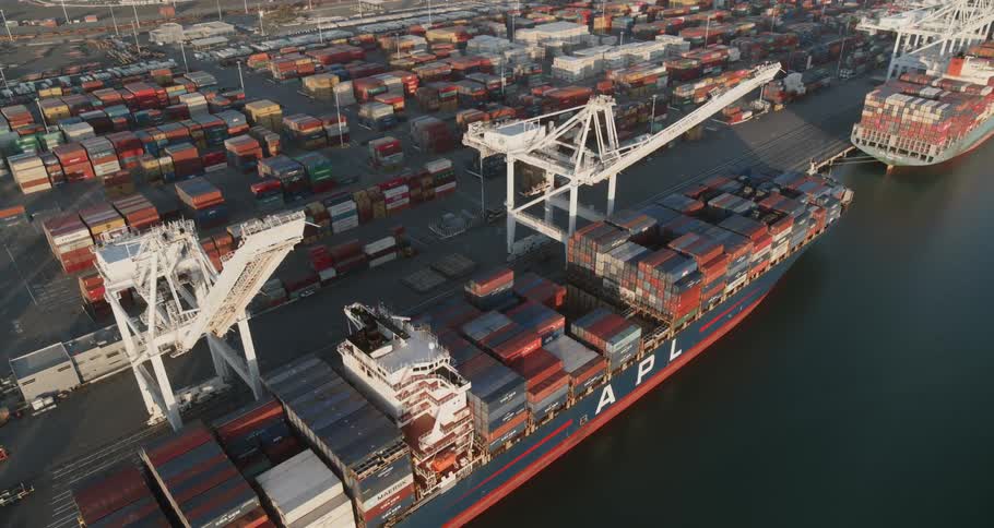 Cargo containers are stacked high on a shipping boat anchored in the water