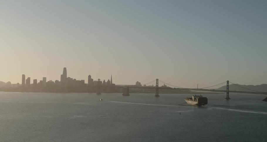 A cargo ship rides towards a downtown port