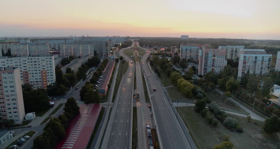 A highway with buildings at the side with the sky in the background