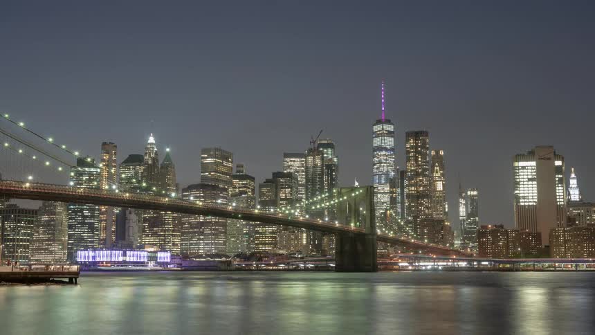 A river with a bridge over it with the city skyline in the background