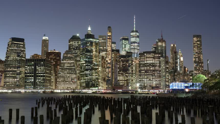 A busy city skyline at night by a port