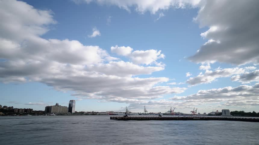 Clouds move over a harbor near a city