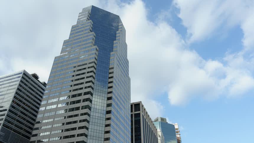 Clouds passing overhead during the day are reflected in skyscrapers glass surface