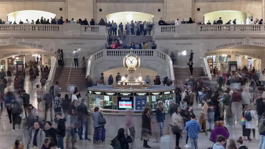 People move through transportation hub near information station