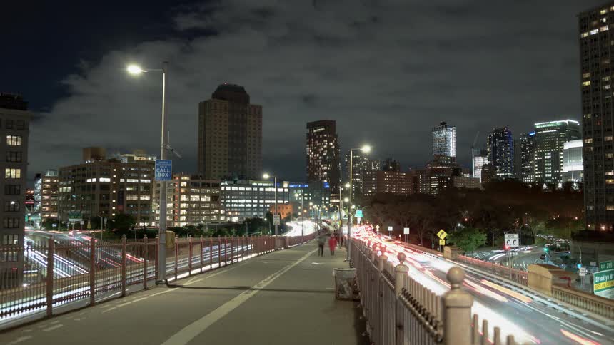Scores of pedestrians walk on an elevated walkway in a city