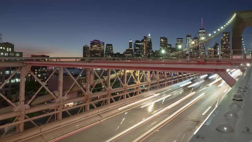 Time lapse view of people standing on a bridge as cars drive across it