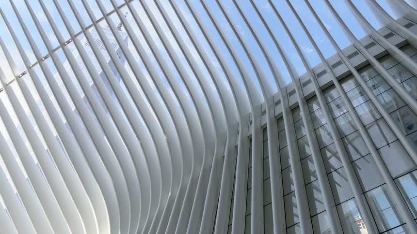 The sky is visible through an atrium connected to a building made up of vertical parallel lines