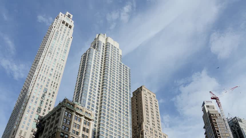 Clouds passing over a row of skyscrapers during the day