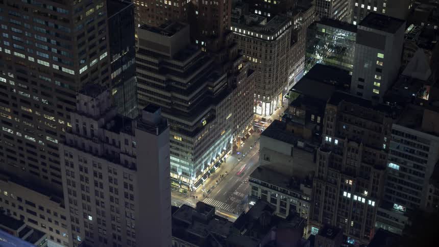Vehicles travel the intersection of a large city at night