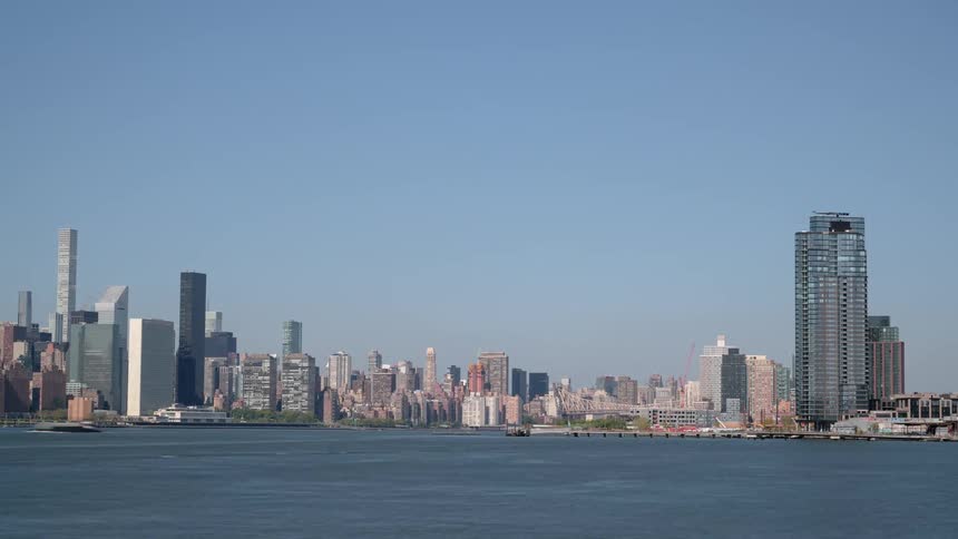Boats move in and out of a large citys harbor