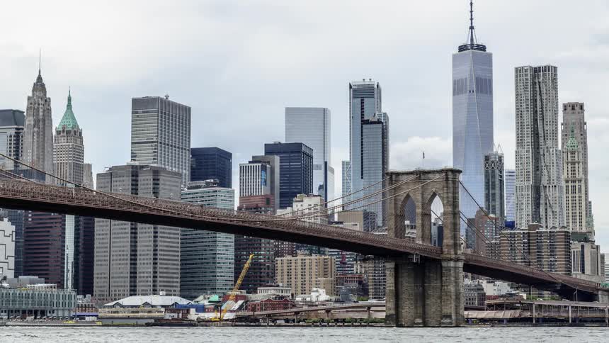 Boats pass under suspension bridge near downtown