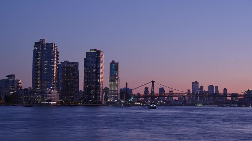 Waves roll across a body of water near a city