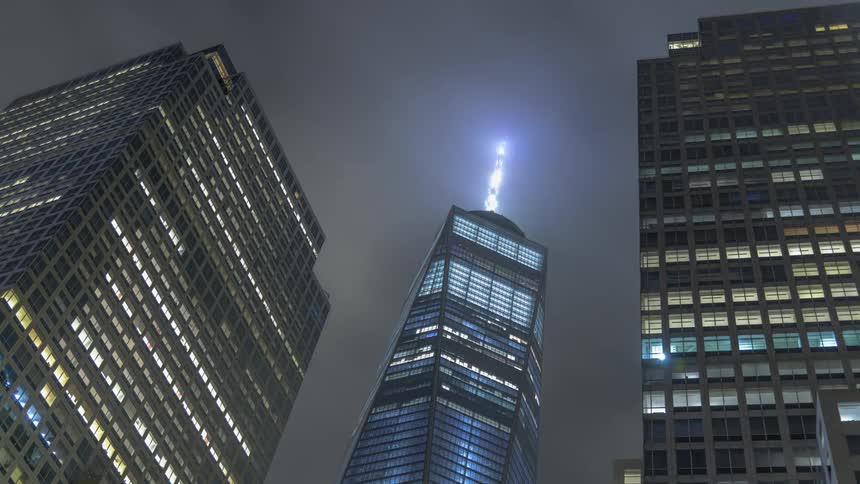 Lights blink and flash on a lighted spire on top of a skyscraper