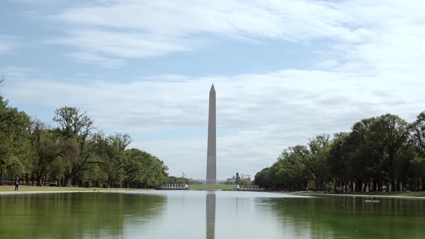 Tourists come and go from a national monument at a pond