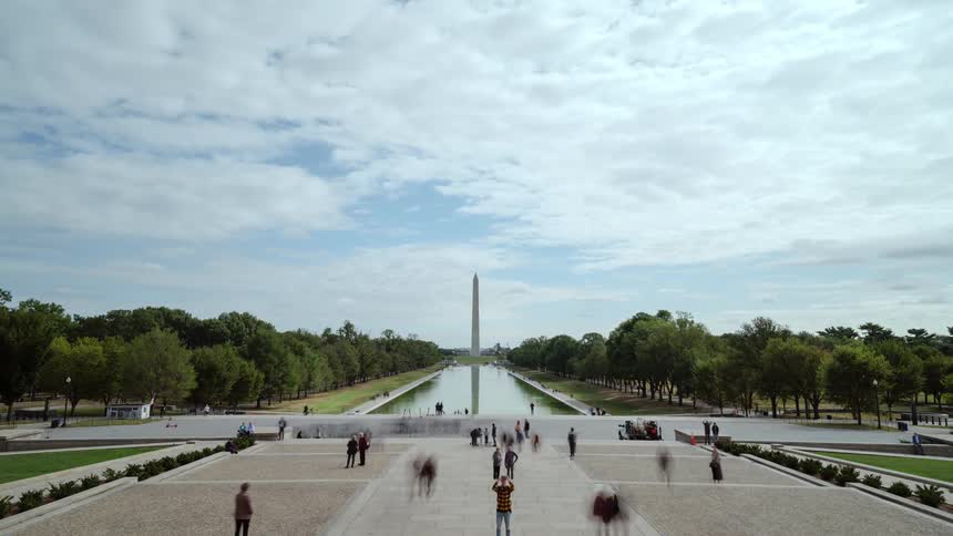 People walk around a monument in washington dc