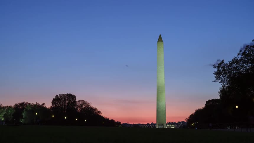 A field with people and a monument in the background