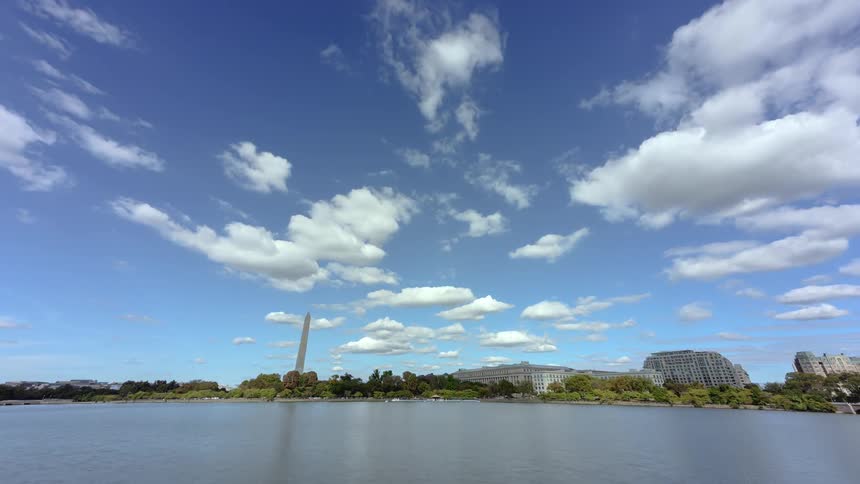 Clouds pass over lake and building campus