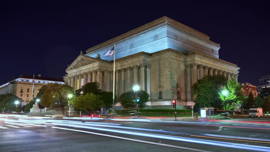 Traffic passes through intersection near government building