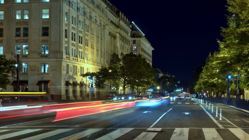 Traffic travels on the city street at night