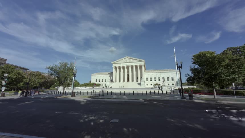People walk around on the grounds of the supreme court building
