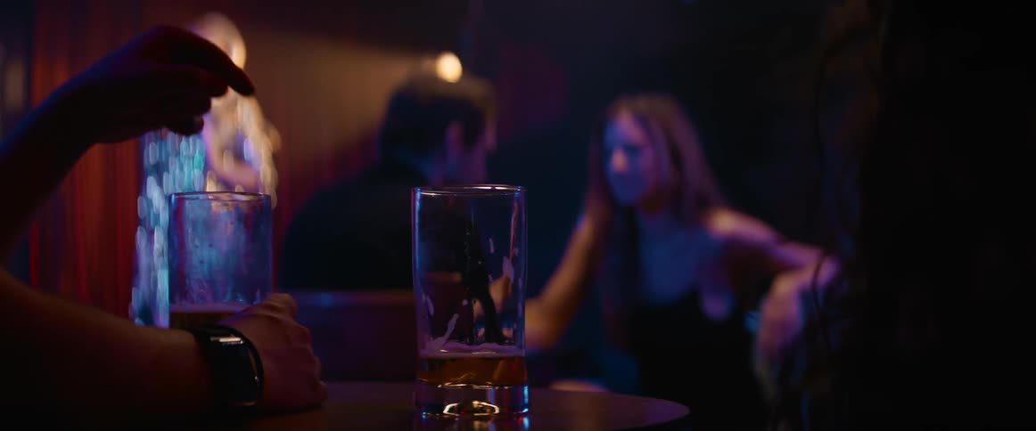 Couple talks at night club while singer performs on stage