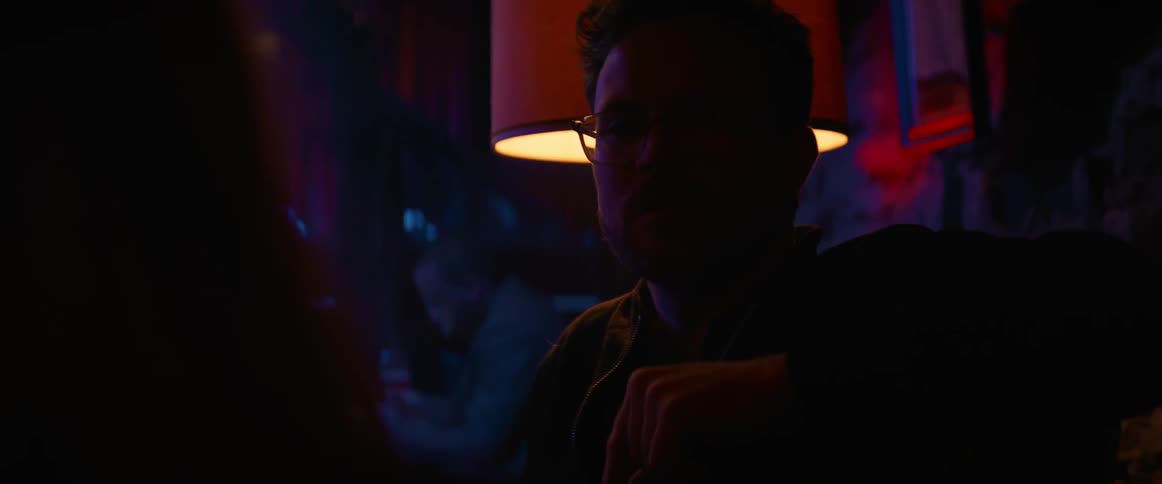 Couple talks in nightclub near table lamp