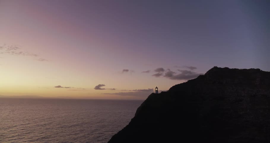 A lighthouse sits high on a rocky coast