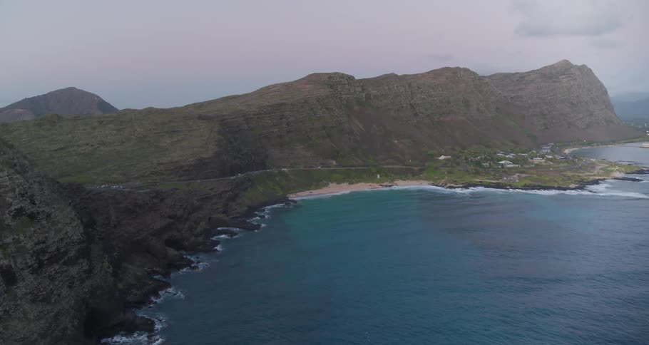 An aerial view of an ocean shoreline with deep blue water