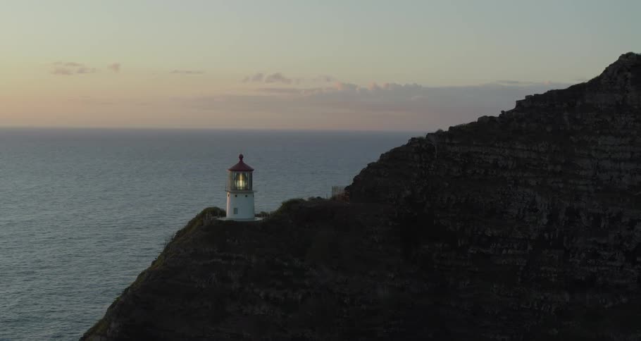 A lighthouse sits on a cliff overlooking the ocean