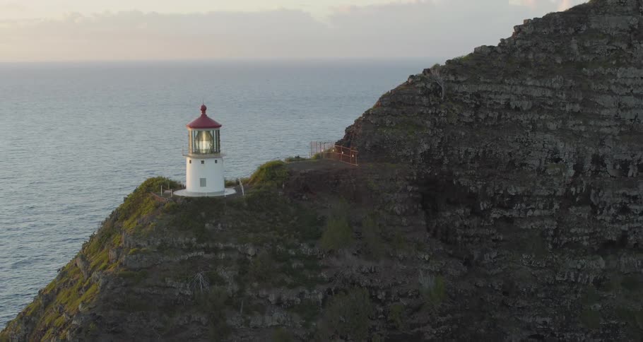 A small lighthouse sits on a cliff above the ocean