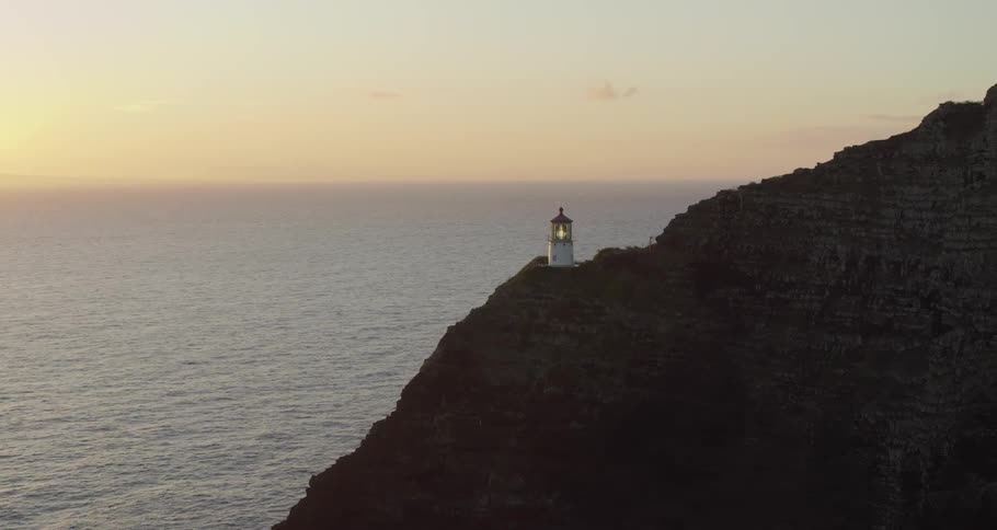 A lighthouse sits on a cliff above the ocean