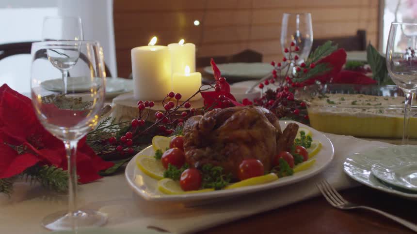 Candles flicker on a table set for a holiday meal