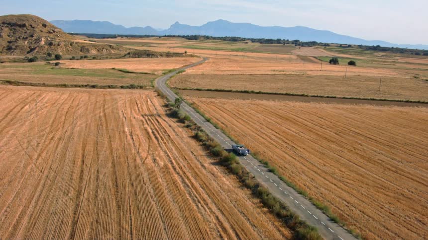 A vehicle travels a lone deserted road