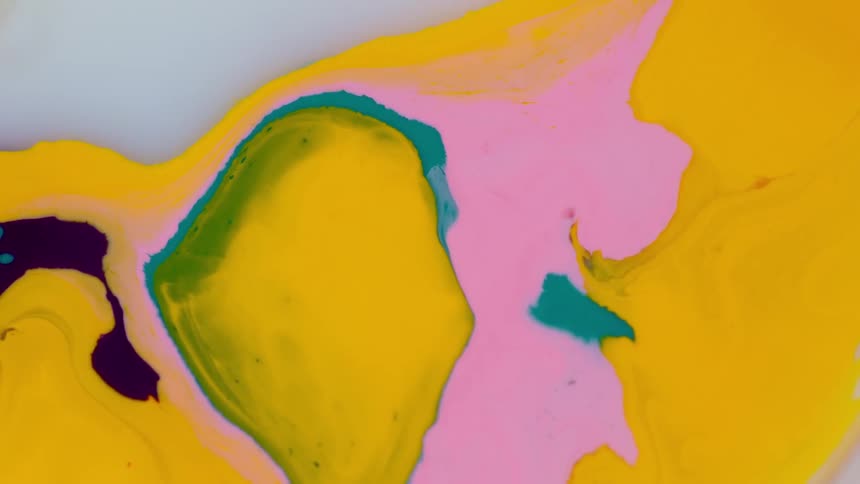 Brightly colored paint on a gray surface blends and flows to shape a unique pattern