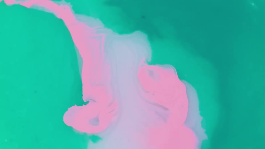 Pink liquid being added to green liquid