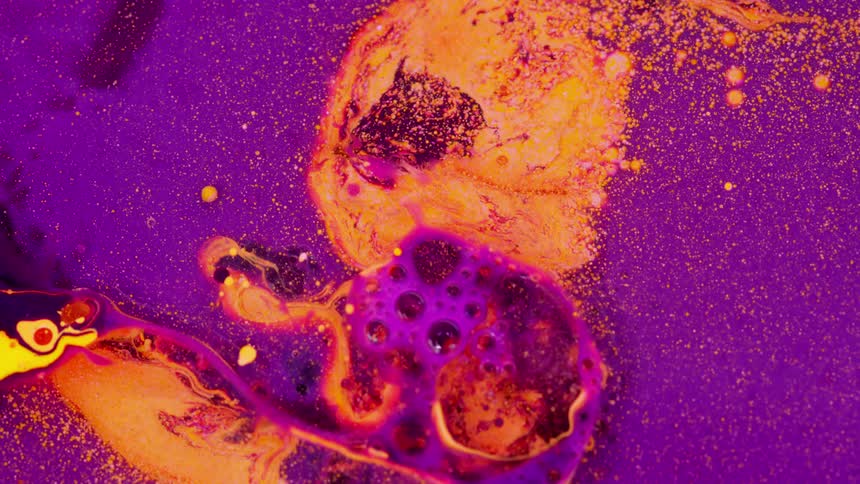 Colorful purple and orange paints bubble and swirl
