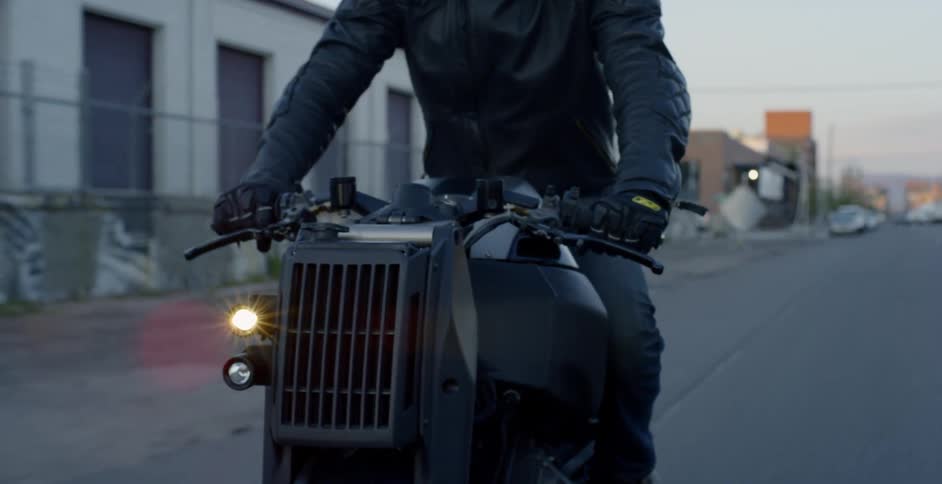 A person rides a small motor bike with front vent and headlamp