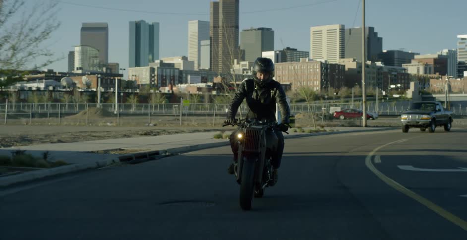 A man rides his motorcycle down a city street