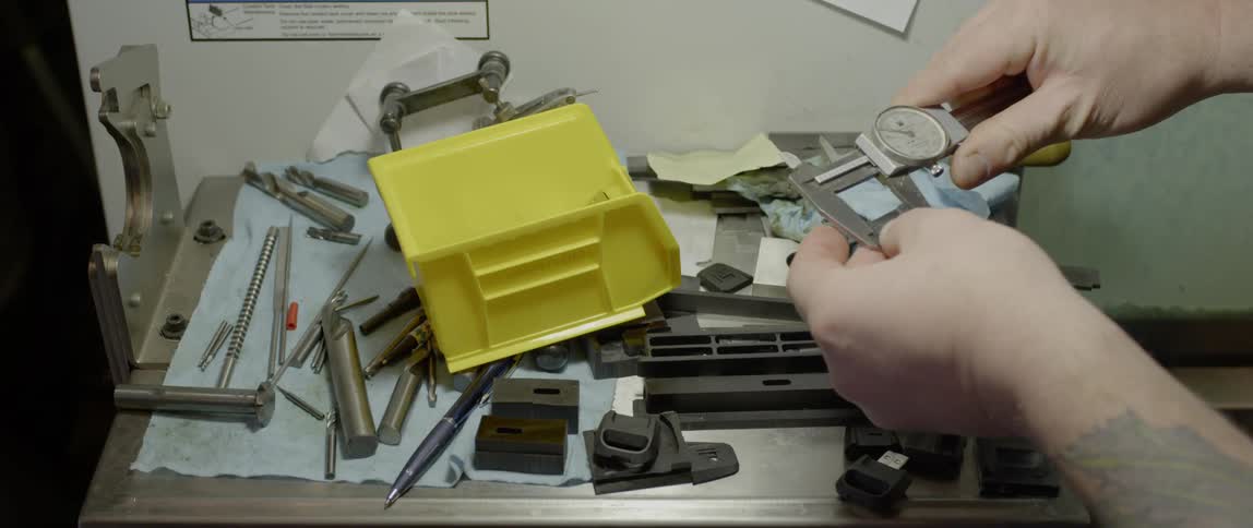 Person measures parts with caliper