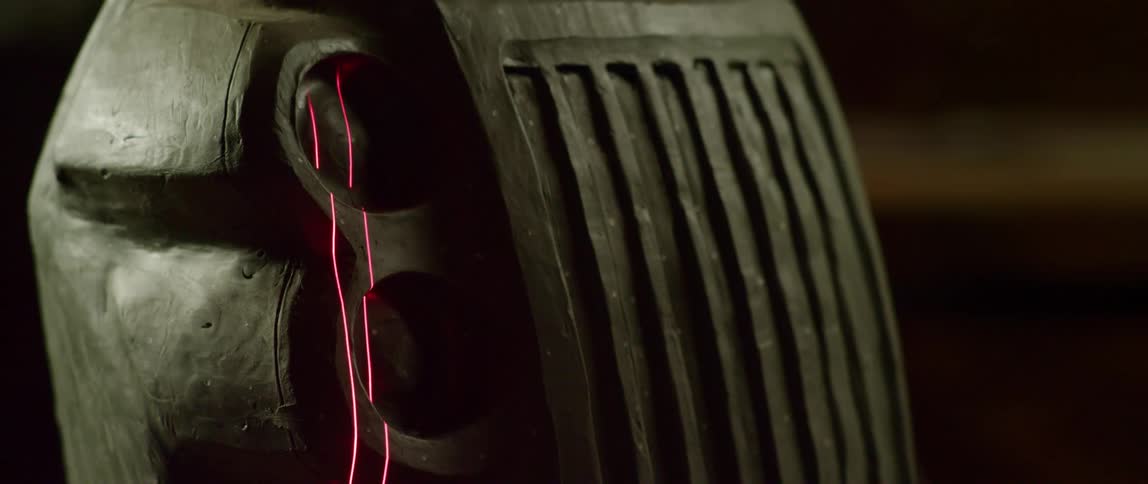 A double line of red laser light slowly scans over a clay mold