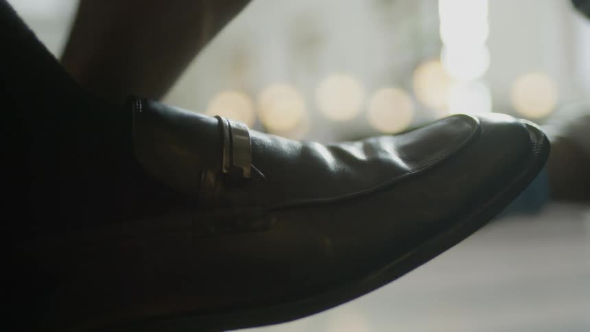 A woman polishes a mans shoes