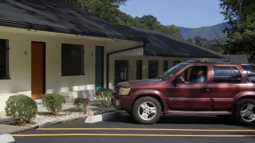 A suv pulls in to a parking spot at a motel