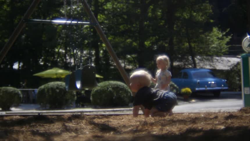 A young boy and girl play in a park