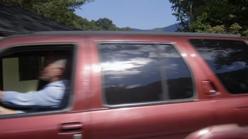 A man parking an suv outside a building