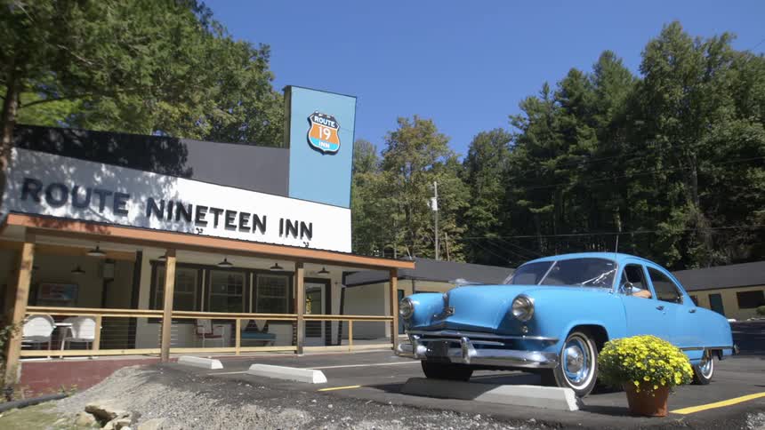 A blue car is parked in the parking lot