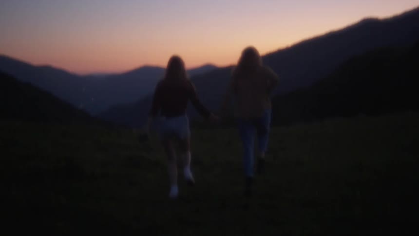 Two women frolic and run outside