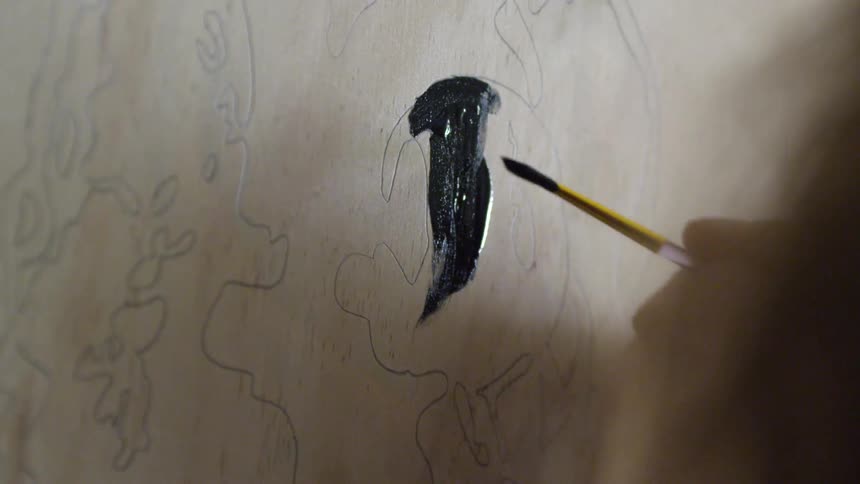 Someone painting with black paint
